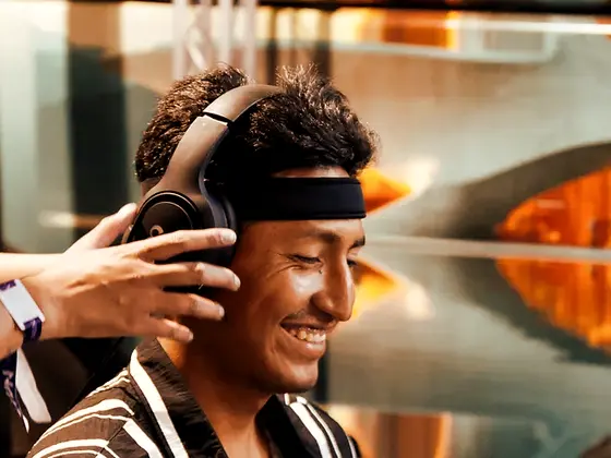 Un jugador sonríe mientras le colocan la diadema EEG